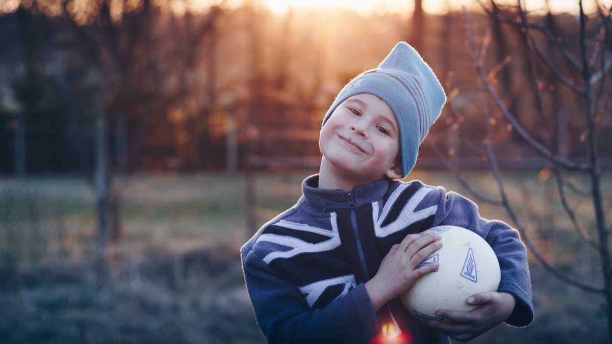 Happy boy holding his football
